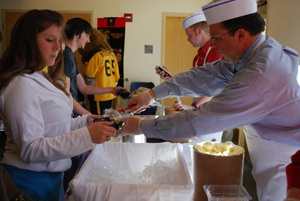 Brian Burnett, VC of Administration and Finance, serves ice cream during contract renewal week in Student Housing